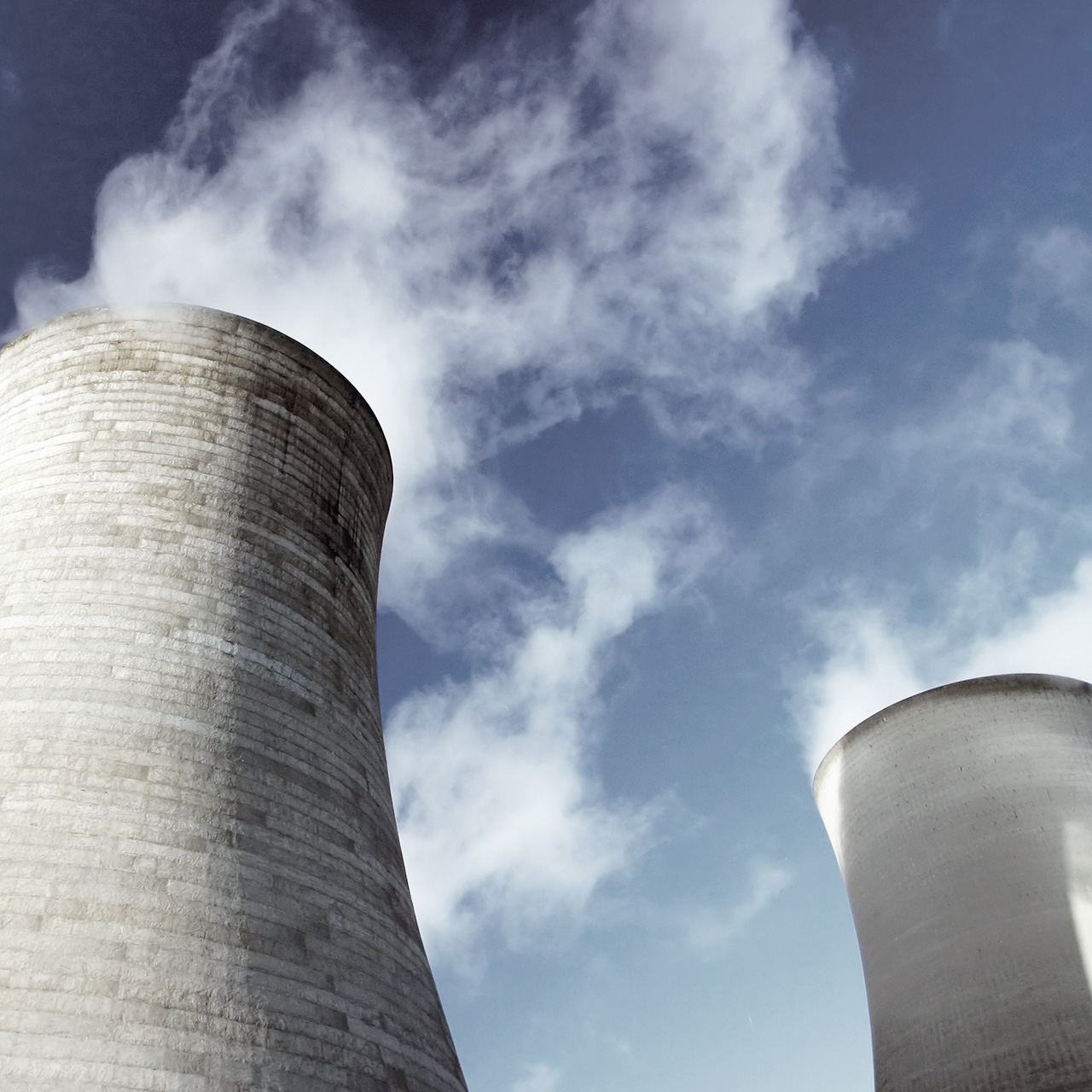 Kraftværk skorstene med blå himmel og røg