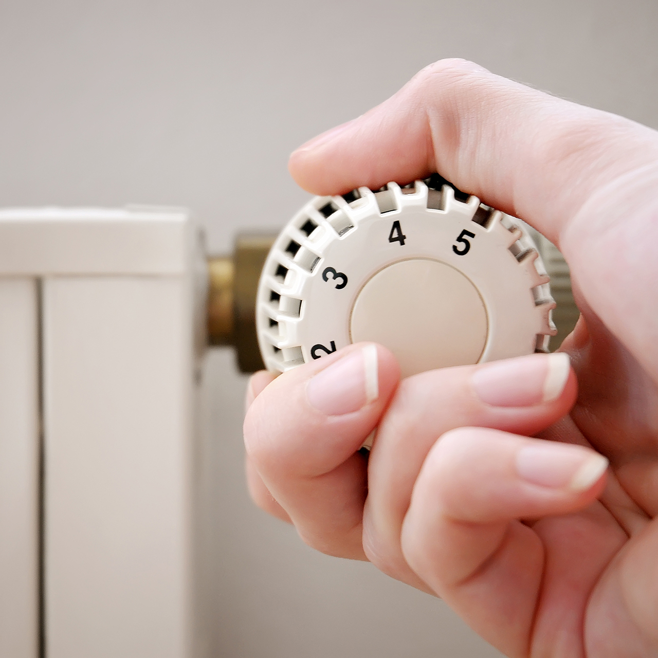 kvinde skruer ned for varmen