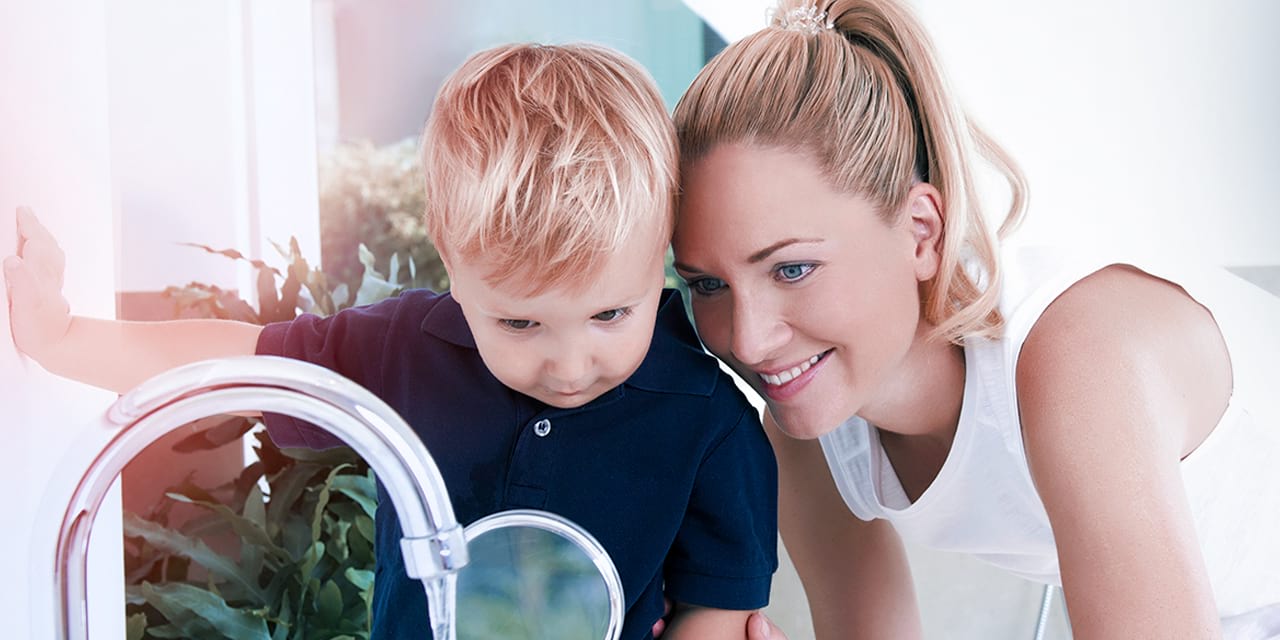 Frau mit Kind begutachten Wasser
