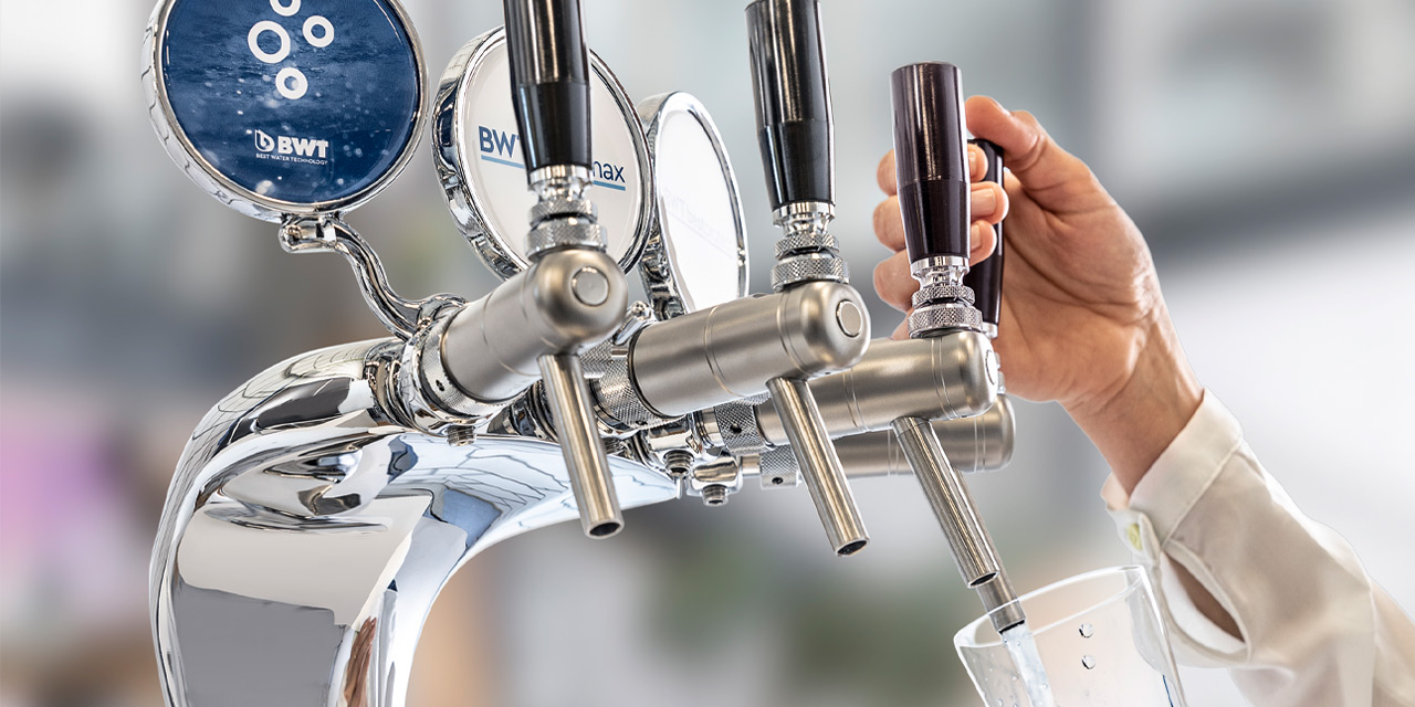 Hand zapft an BWT WasserBar Wasser.