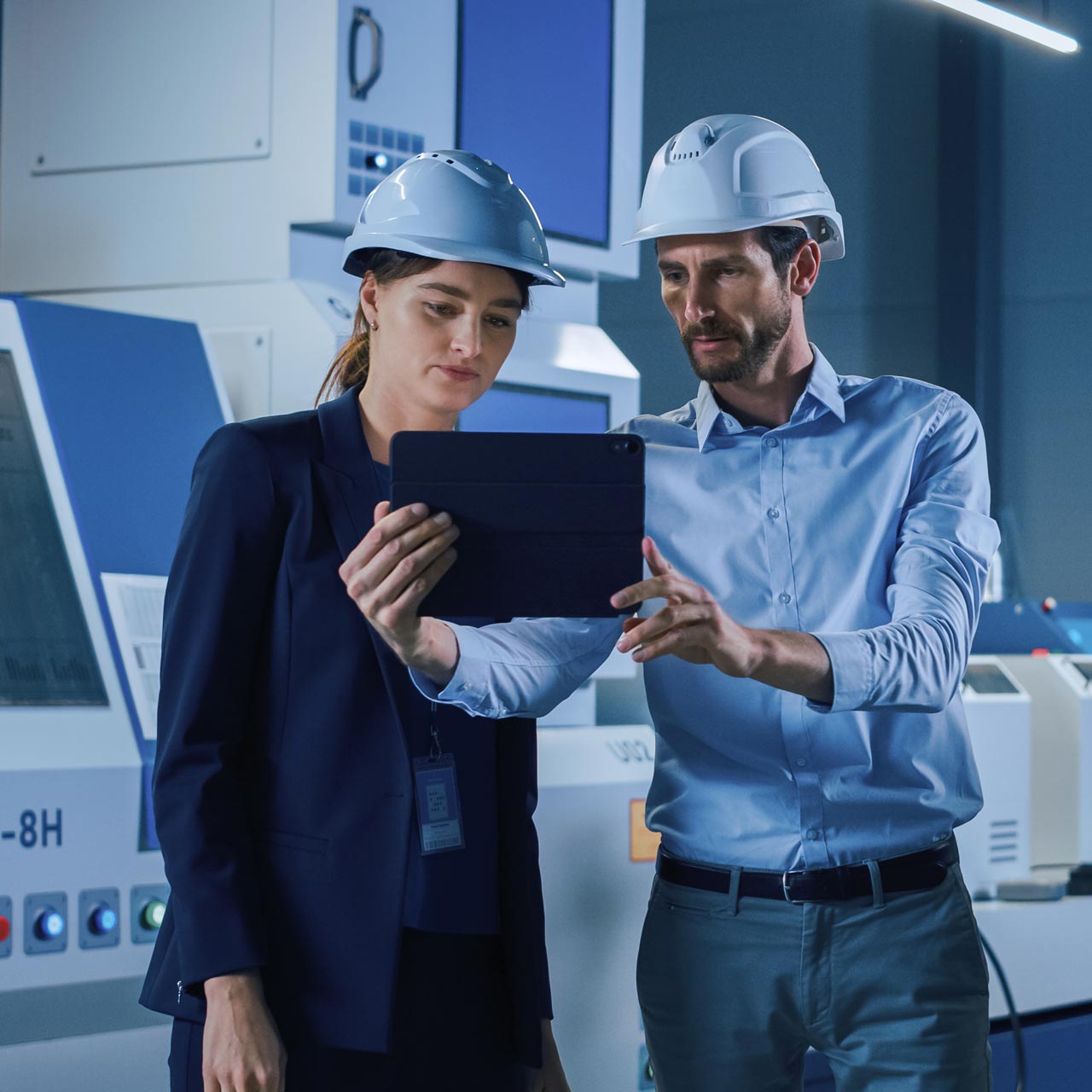 Eine Frau und ein Mann schauen auf ein Tablet. 