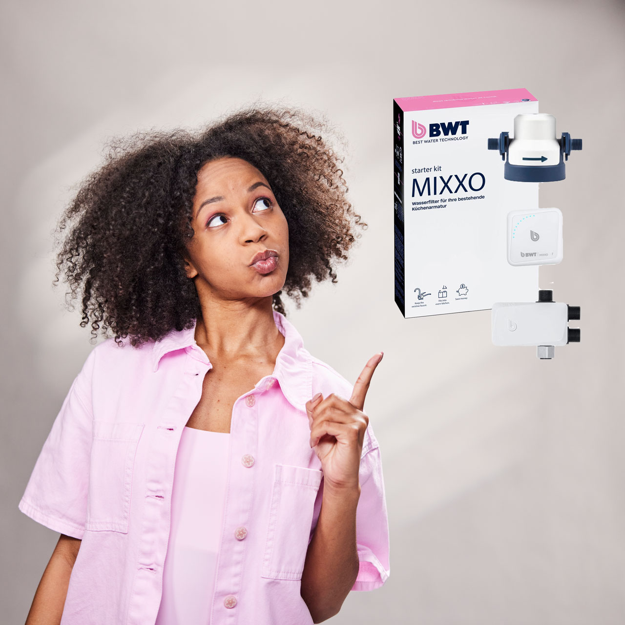 Frau zeigt auf Wasserfilter BWT Mixxo.