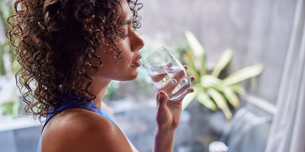 Frau trinkt ein Glas Wasser.