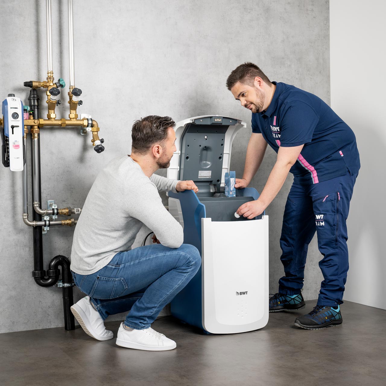 Servicetechniker spricht mit Kunde über Enthärtungsanlage.