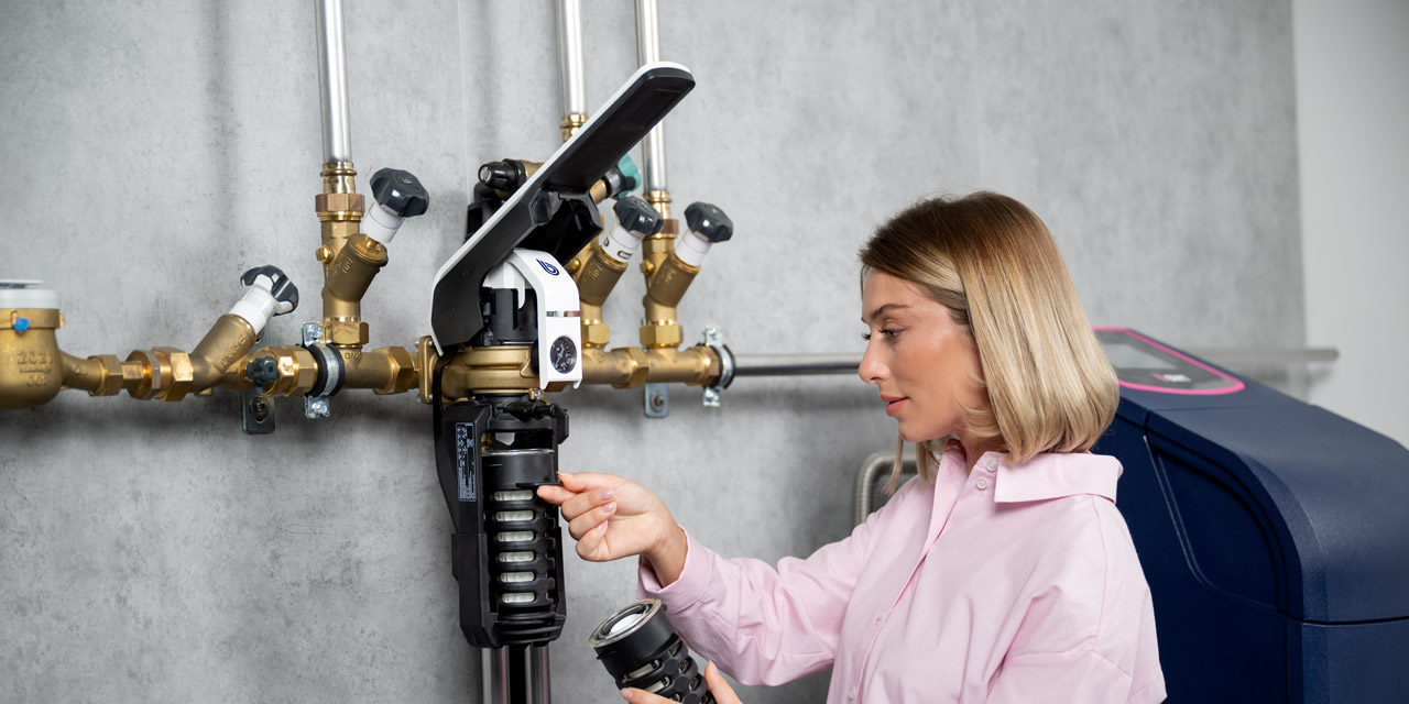 Frau wechselt Filter bei BWT E1 Einhebelfilter.