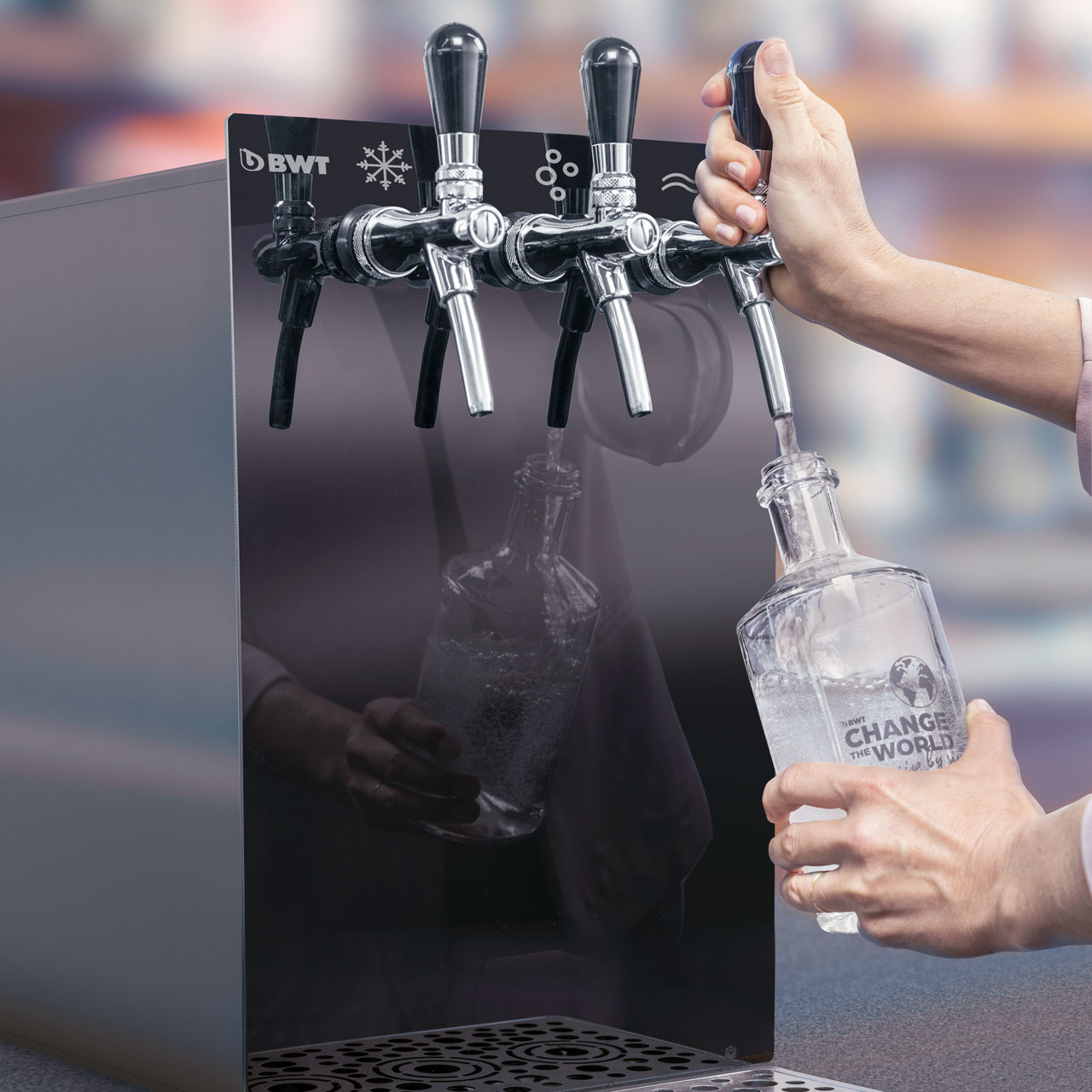 Wasser aus der BWT WasserBar fliesst in Karaffe.