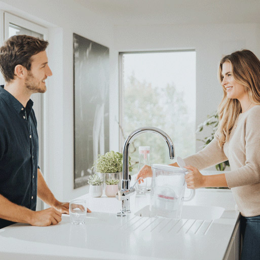 Frau lässt Wasser aus Wasserhahn. 
