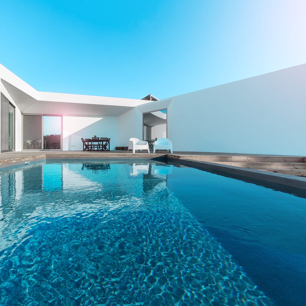 Pooltrend für 2020: Pool mit dunklem Innenraum, im Hintergrund ein weißes Haus.