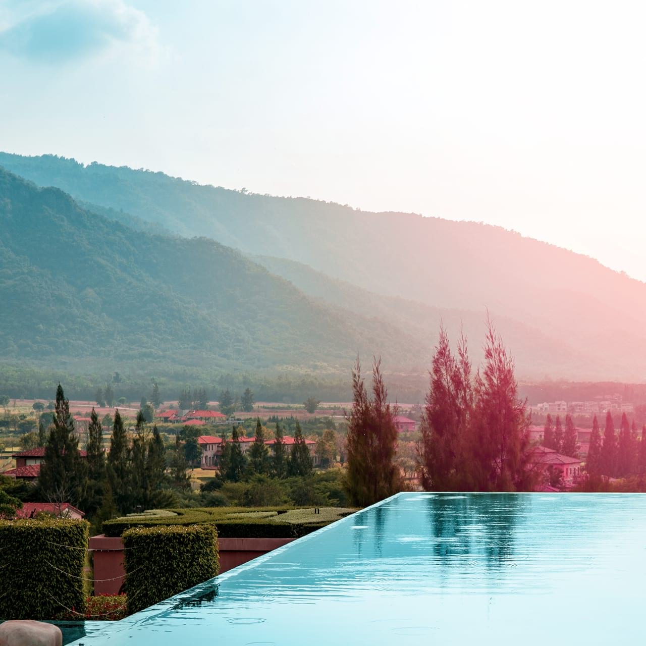 Outdoor-Pool im Garten, im Hintergrund Berge.
