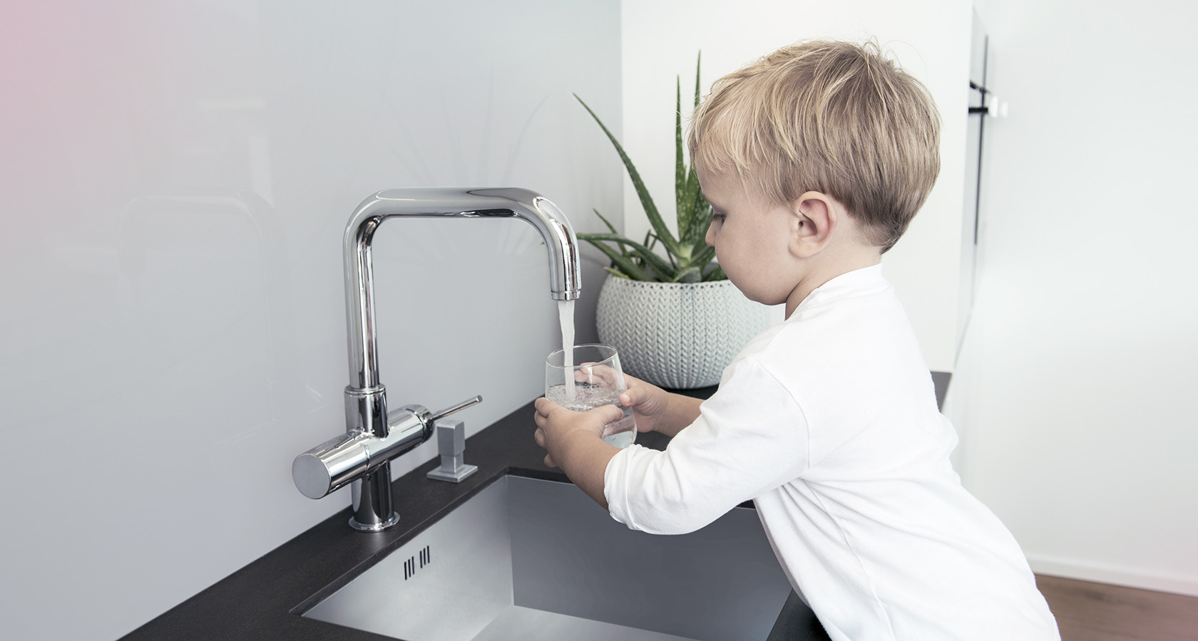 Junge füllt Wasser in Glas