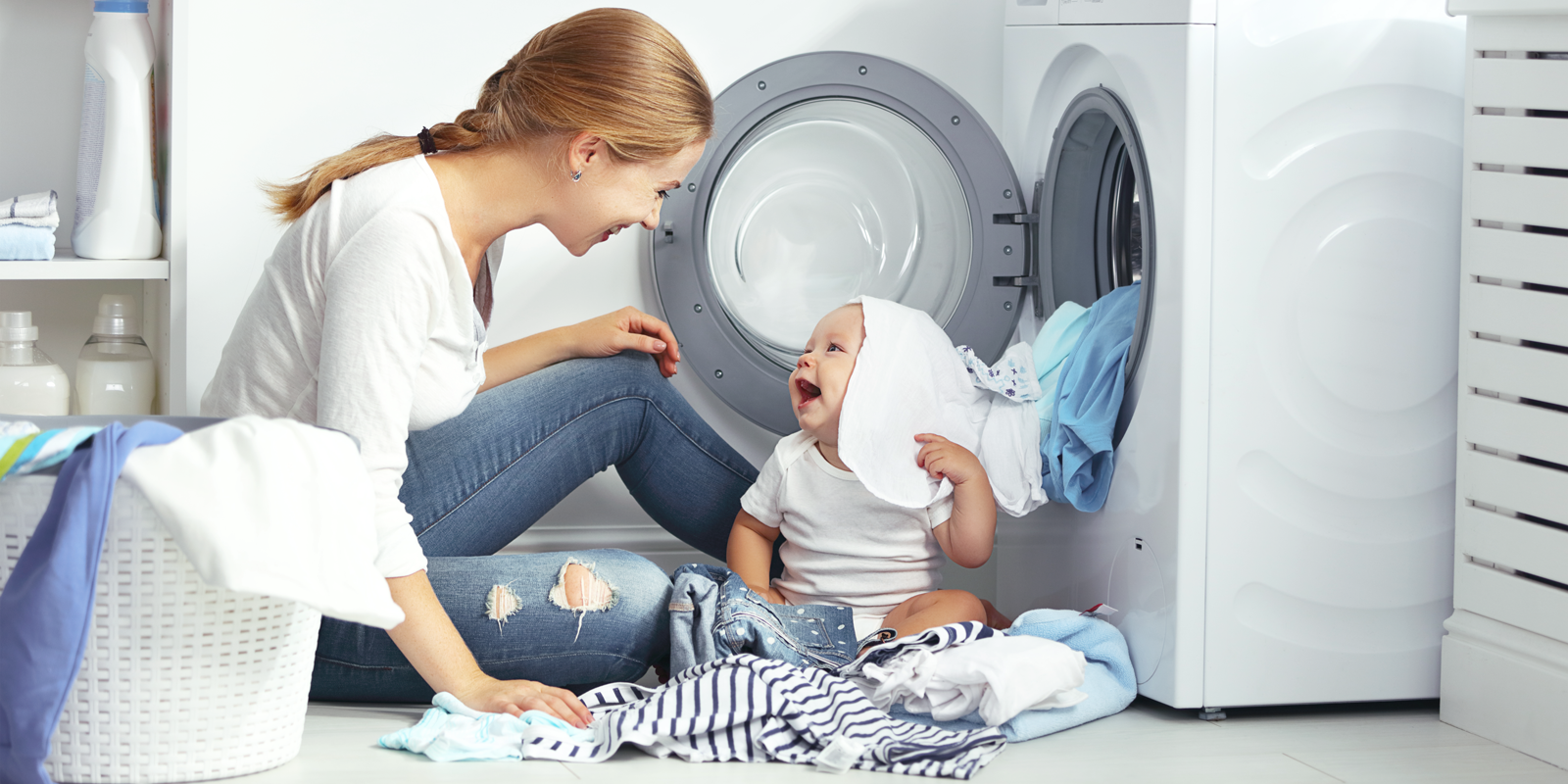 Mor og baby ved vaskemaskine
