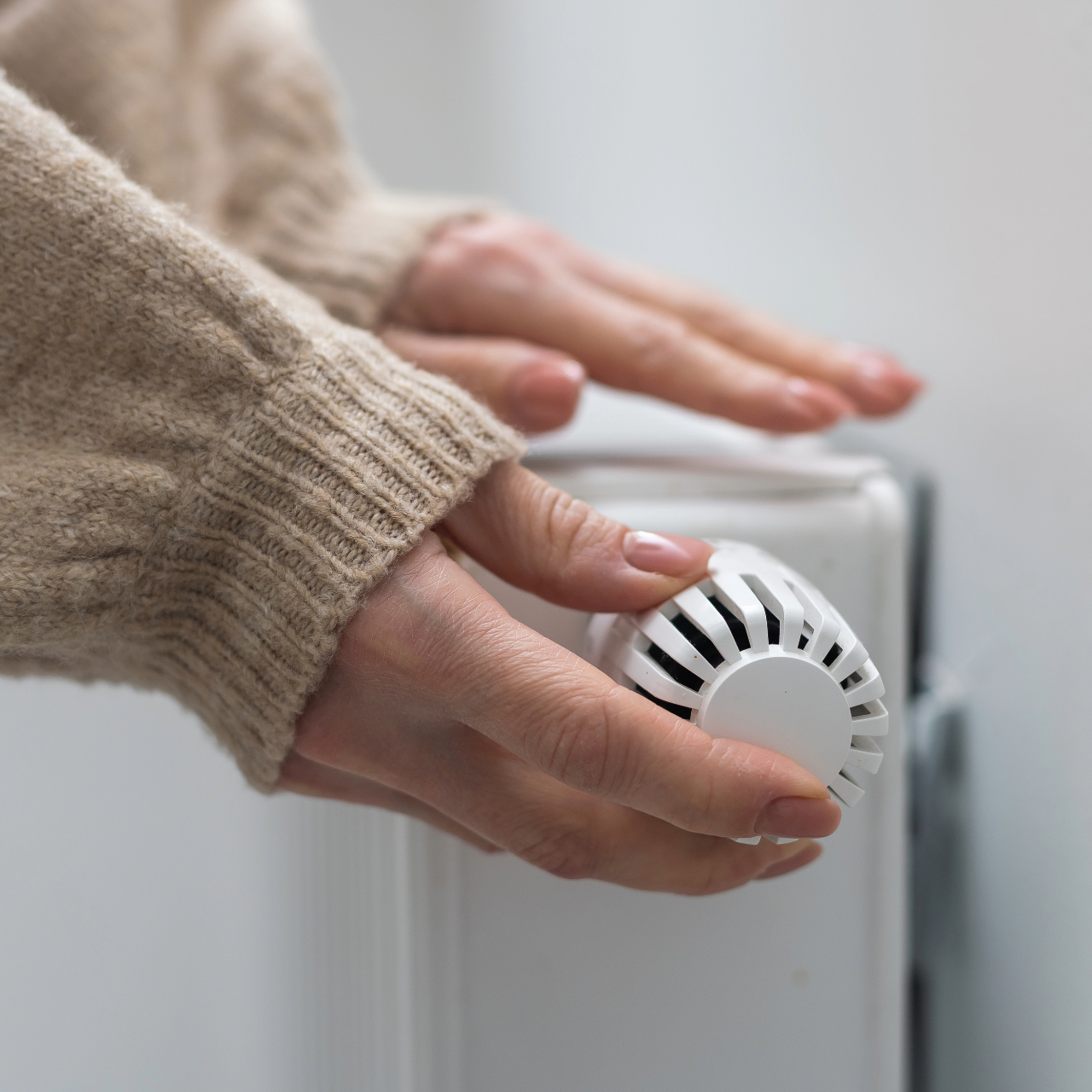 kvinde skruer ned for varmen