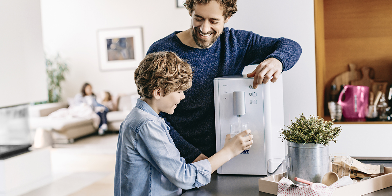 Father explains the water dispenser to his son