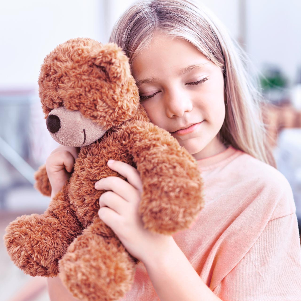 Kind schmust mit einem Teddybär.