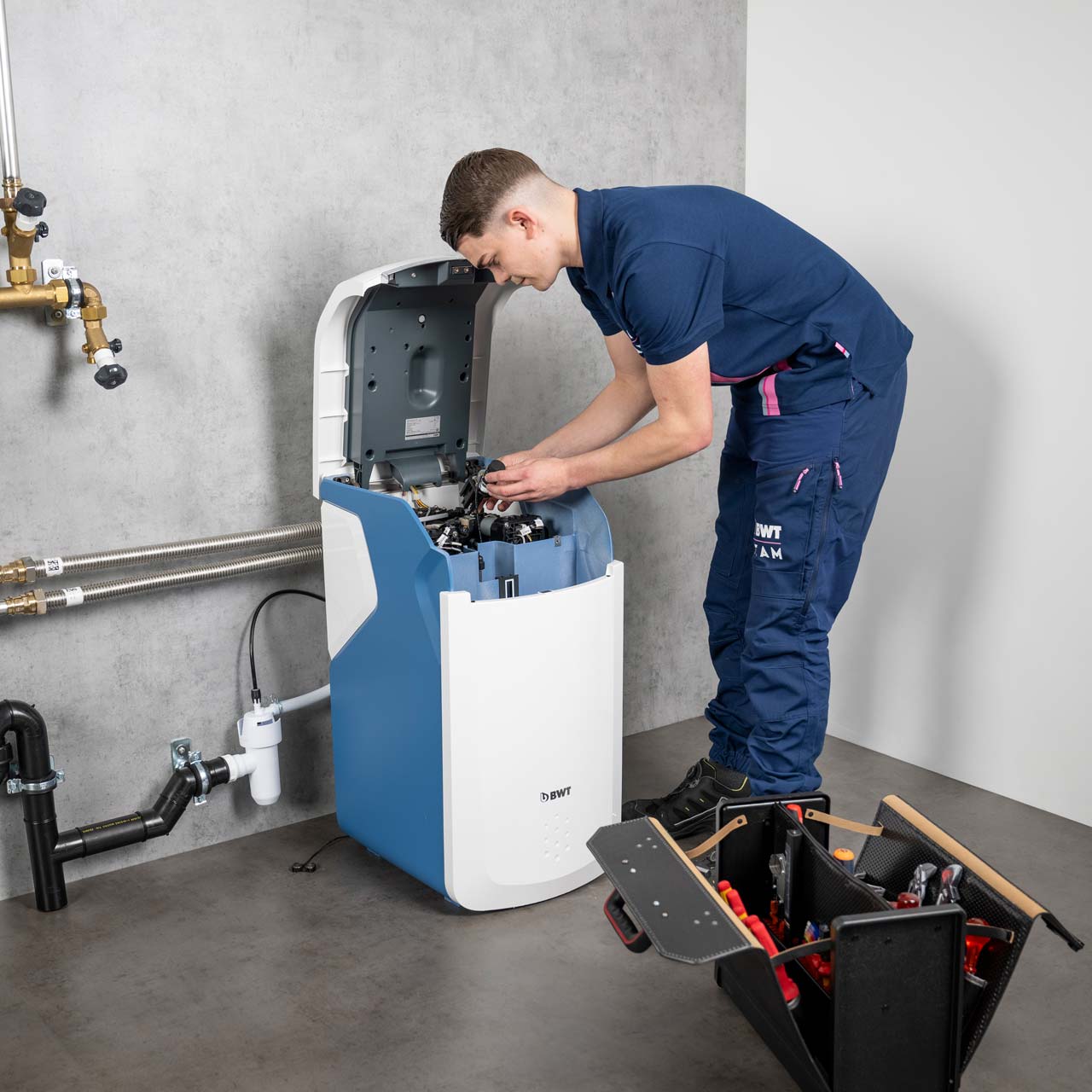 Un technicien travaille sur un adoucisseur d'eau. 