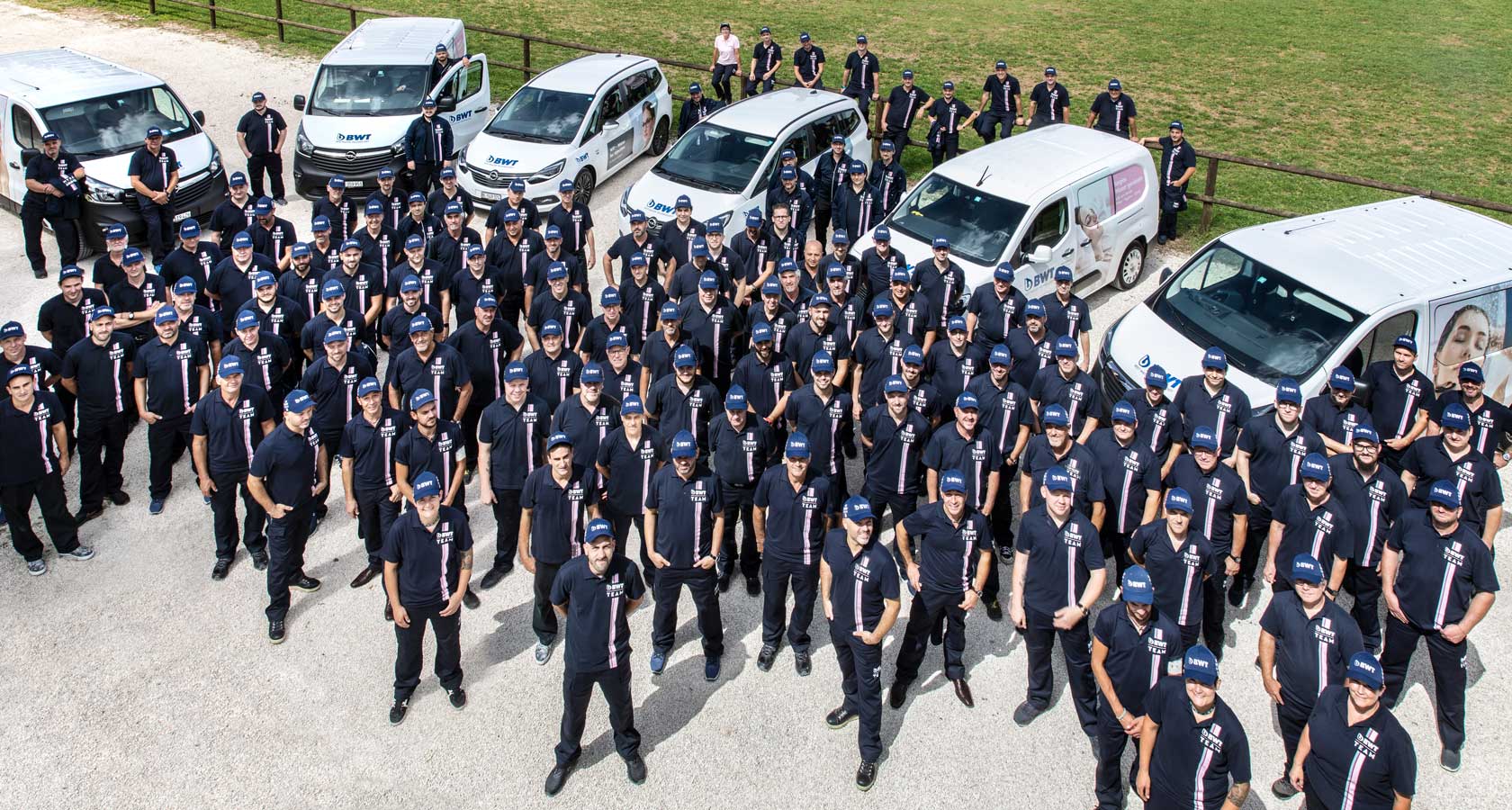 Alle BWT Servicetechniker stehen vor den Serviceautos, Foto von oben.