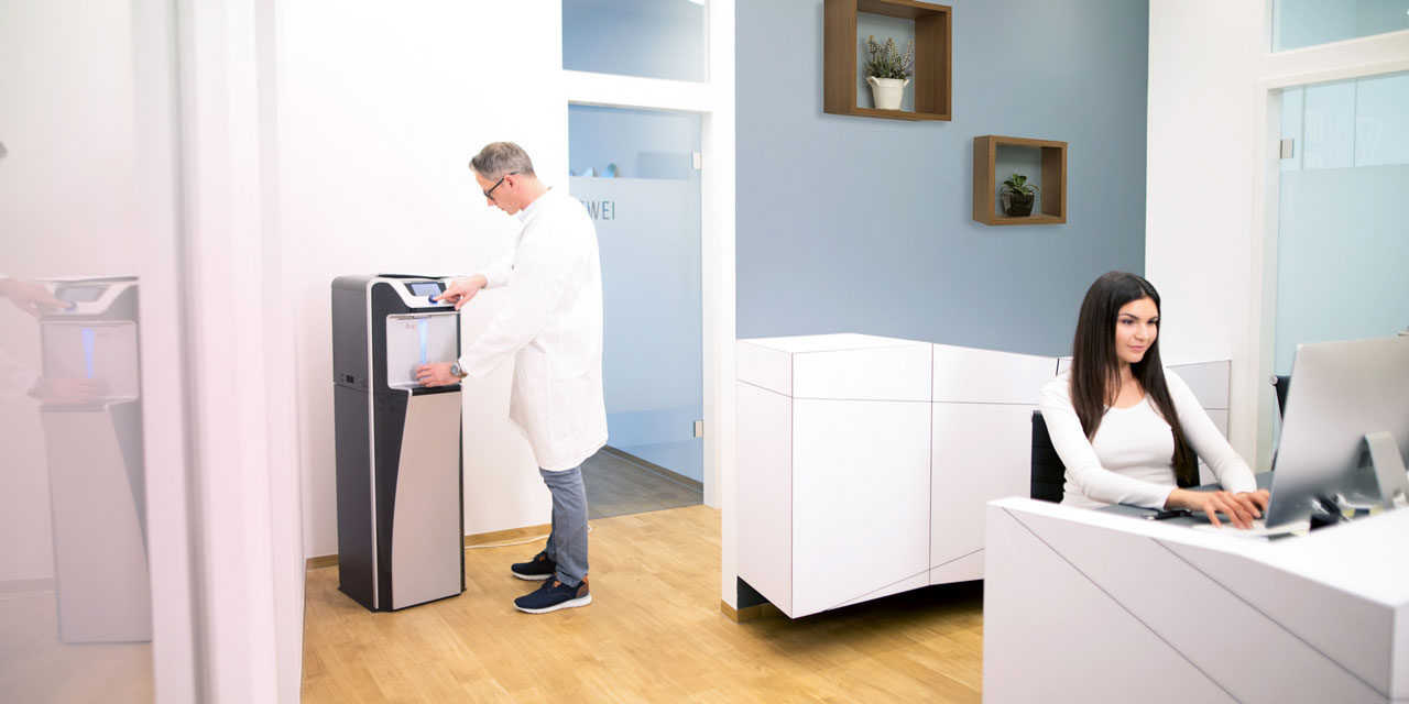 Le médecin se procure de l'eau à une fontaine à eau.