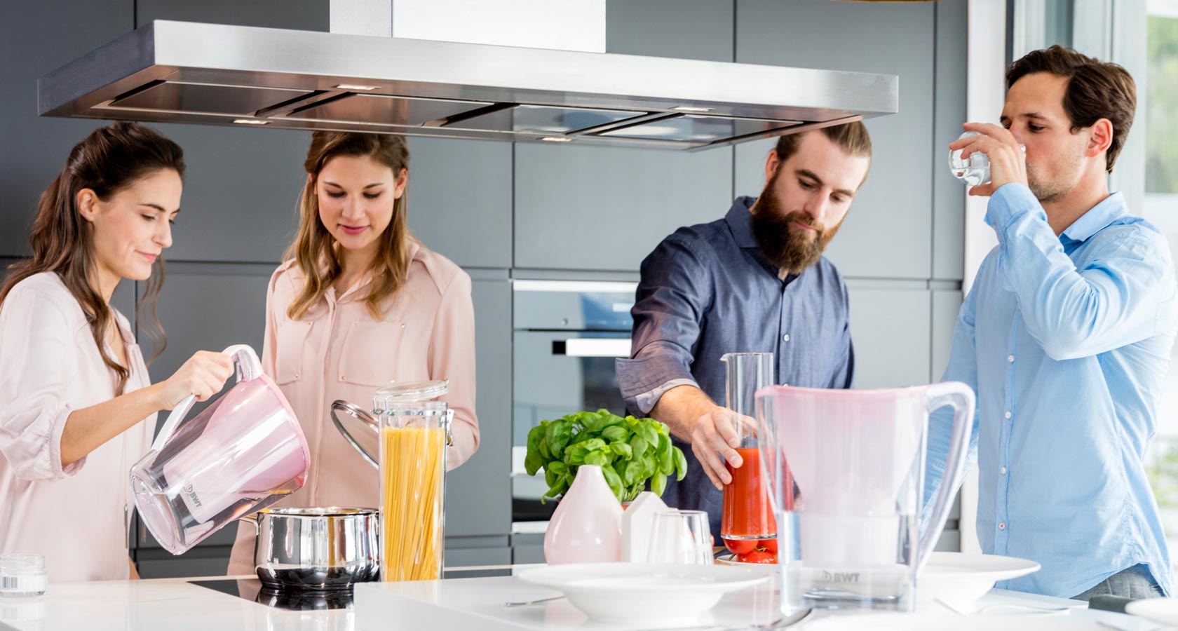 Le groupe se tient dans la cuisine et boit de l'eau.