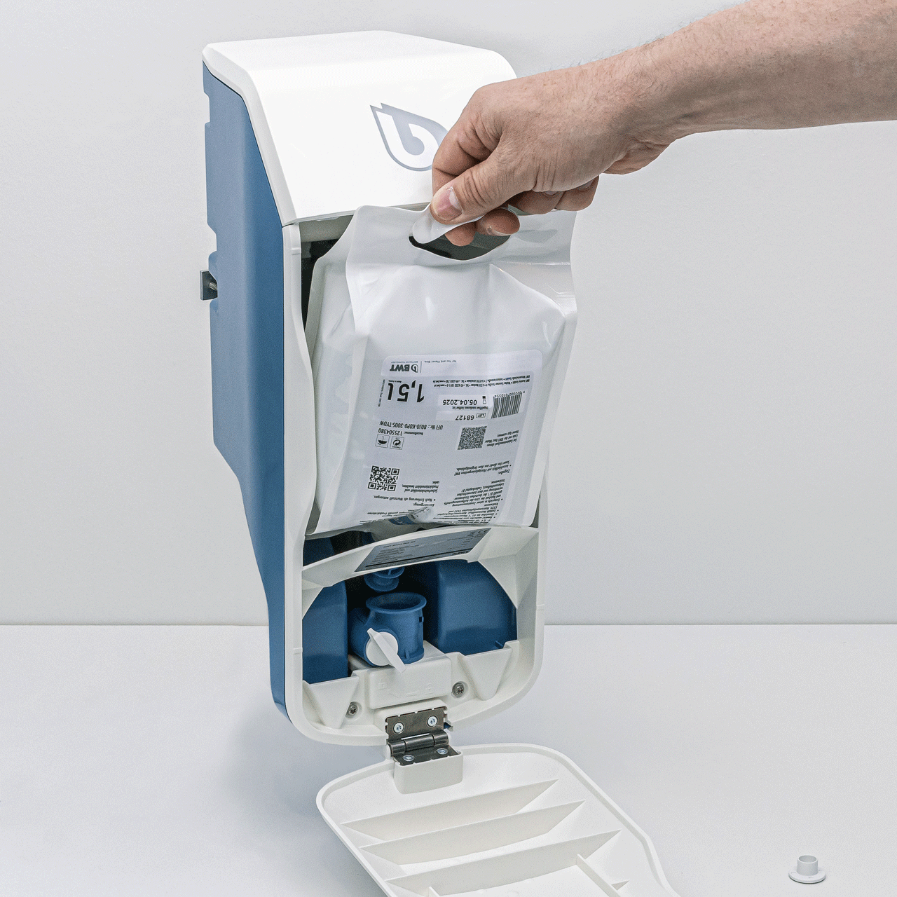 Pompe doseuse bleue et blanche avec sachet de principe actif