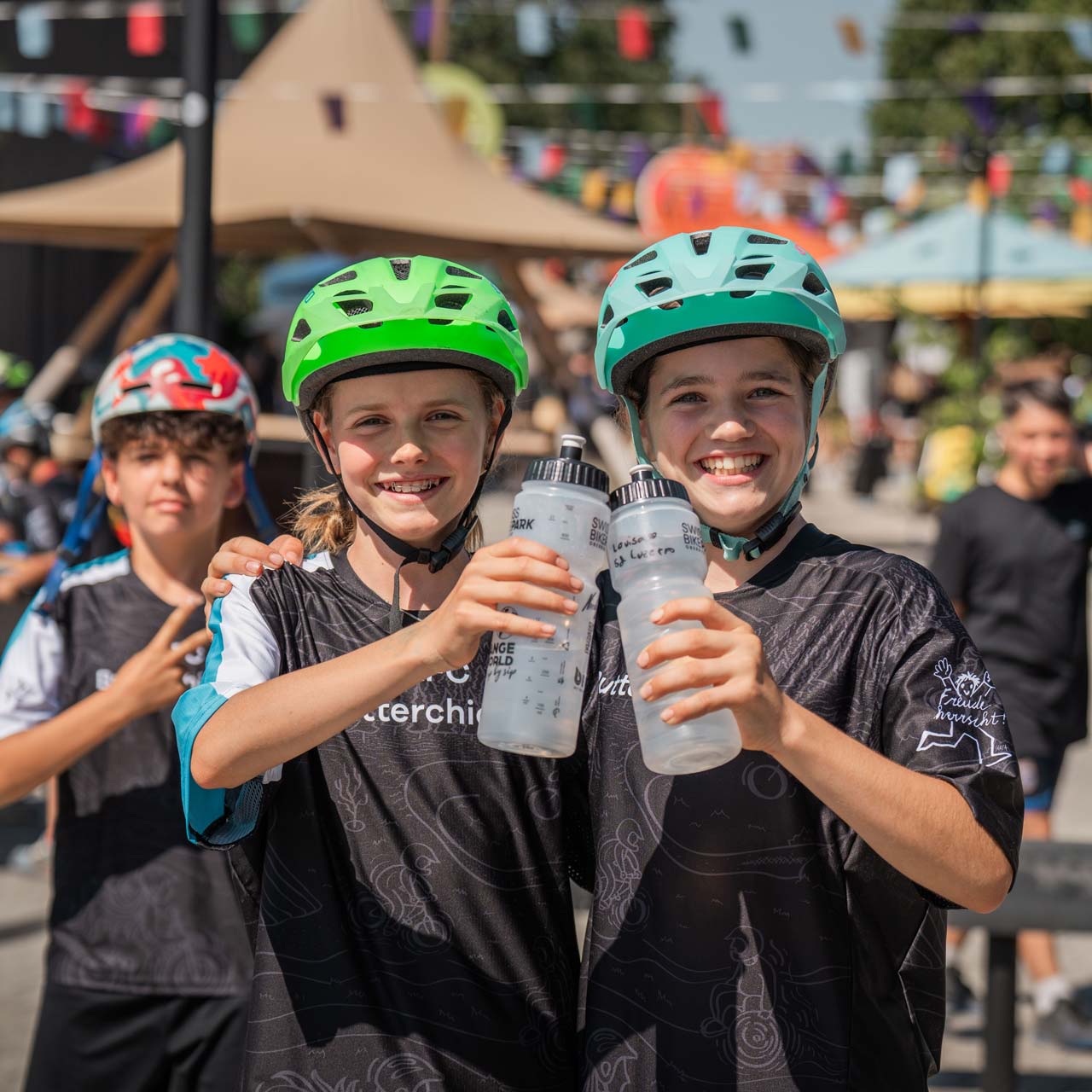 Deux filles tiennent une bouteille BWT transparente à la main et sourient.