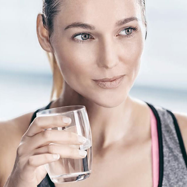 femme boit de l'eau au sport