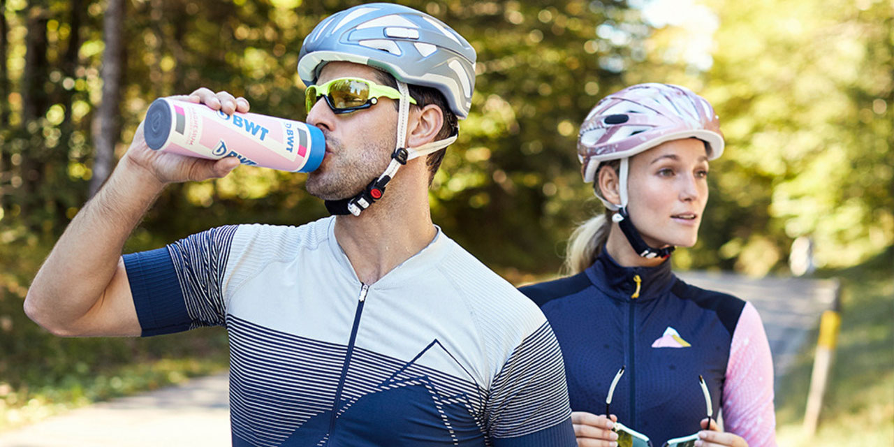 Deux cyclistes boivent de l'eau d'une gourde BWT