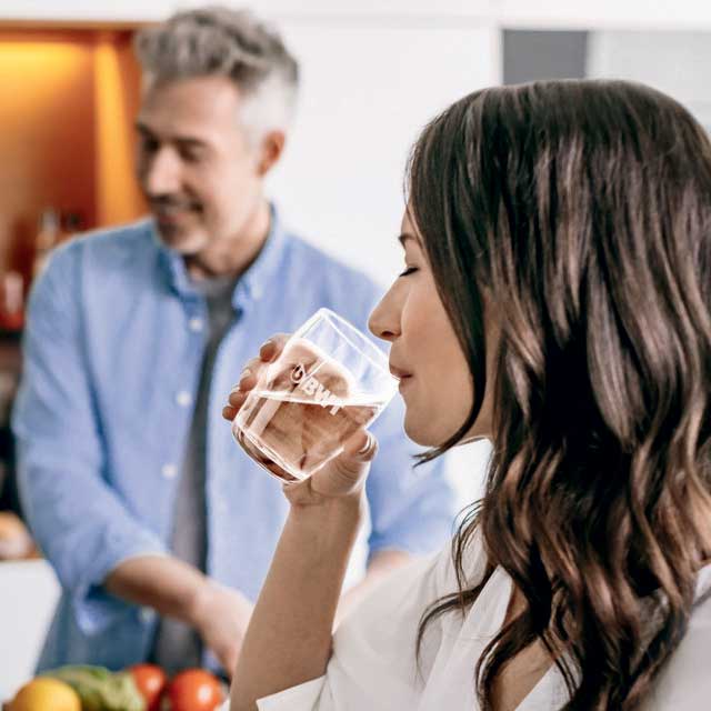 femme boit de l'eau à table