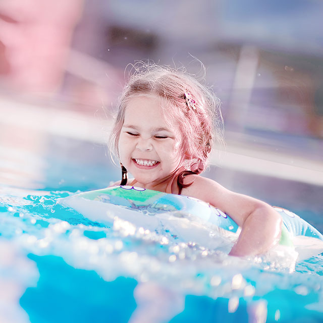 Petite fille se baigne dans une piscine