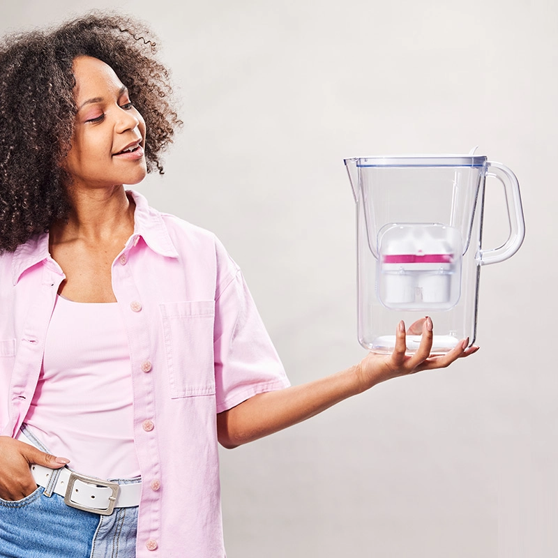 Frau mit Wasserfilter Aqualizer BWT mit Magnesium Kartusche