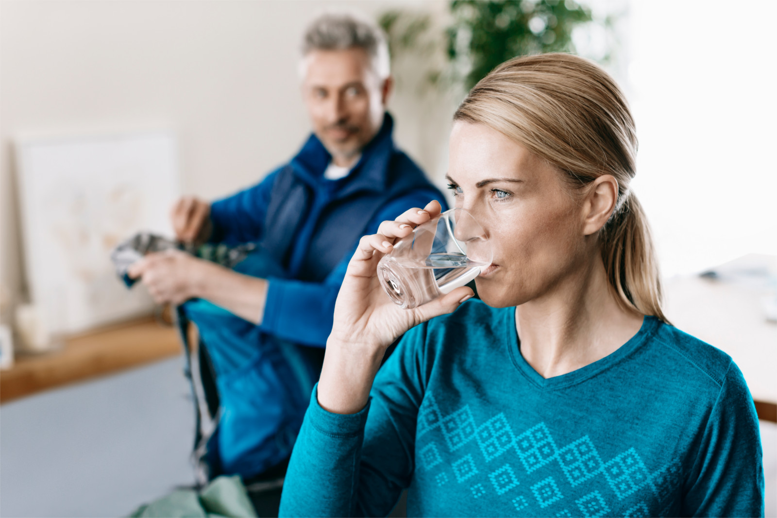 Dame trinkt gefiltertes Wasser aus Tischwasserfilter Slim