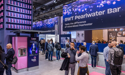 Visitors gather at the BWT Pearlwater Bar, where a large sign invites attendees to taste mineralized Pearlwater. 